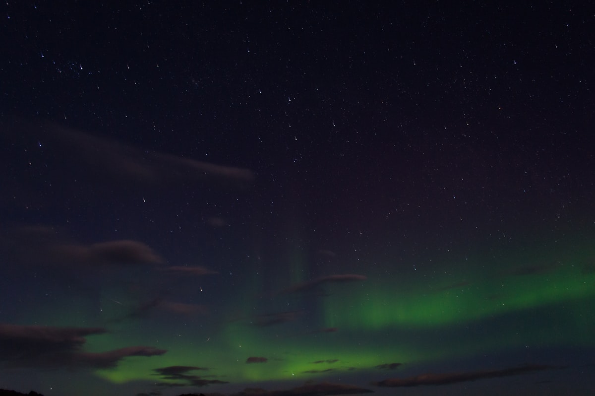 Bright green aurora borealis curtains rippling across a dark Iceland night sky, the kind of display the declining phase of Solar Cycle 25 still delivers.