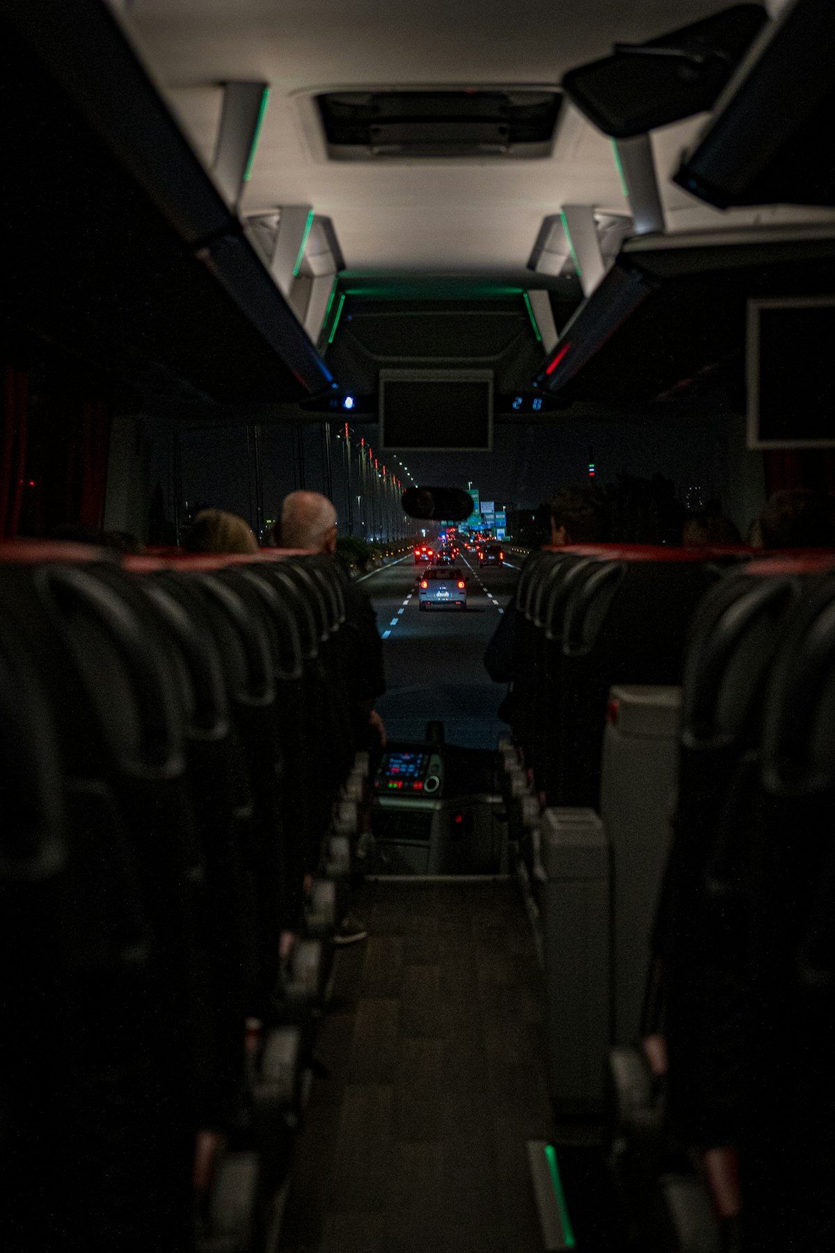The view down the aisle of a coach at night, lit only by the glow of the windscreen. Once the tour is running, the refund policy has already changed.