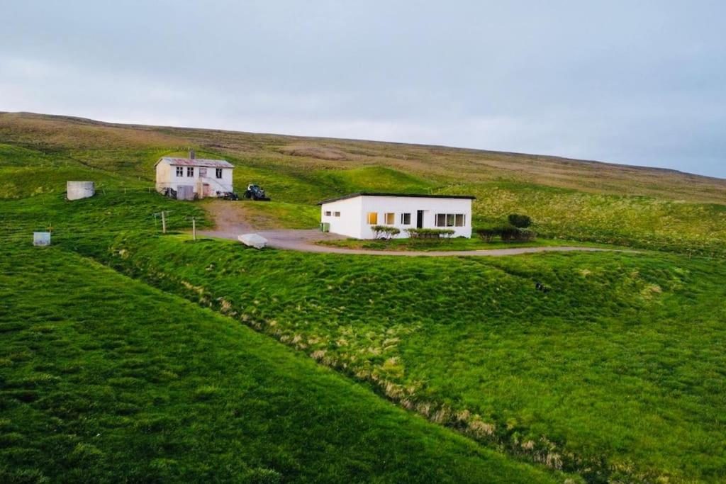 Aerial view of the Óspaksstaðir farmhouse set in open countryside