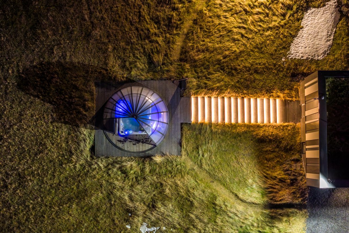 The glass viewing dome at Landhotel lit blue from inside, seen from directly above at night