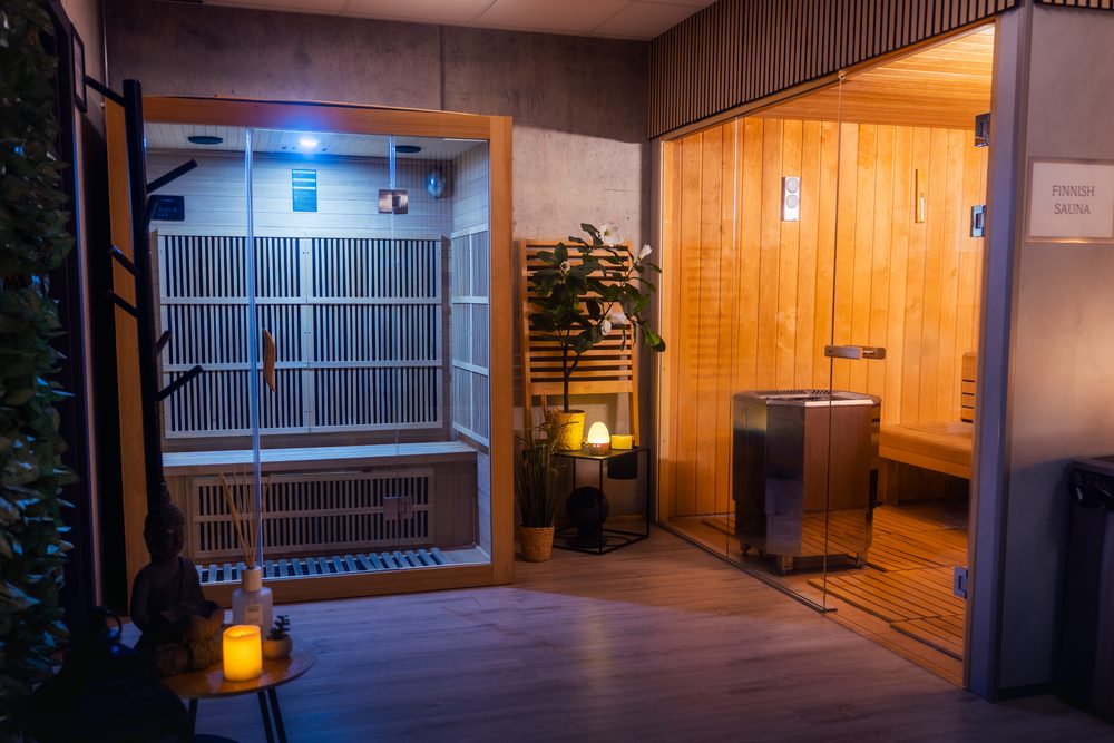 The wellness area at Landhotel, an infrared cabin lit blue on the left and a warm-lit Finnish sauna behind glass on the right